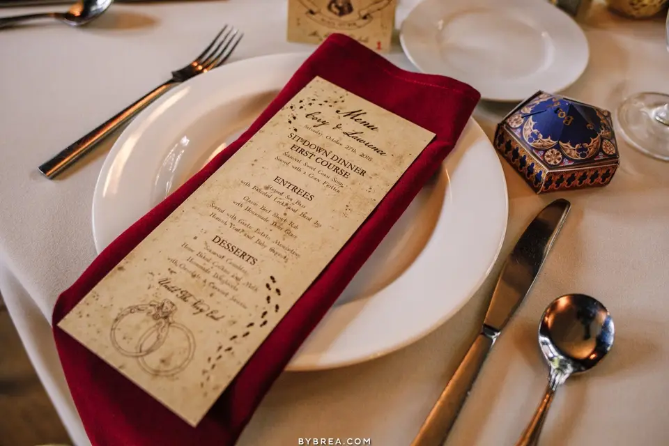 Parchment-style dinner menu on a red napkin and white plate with a place setting