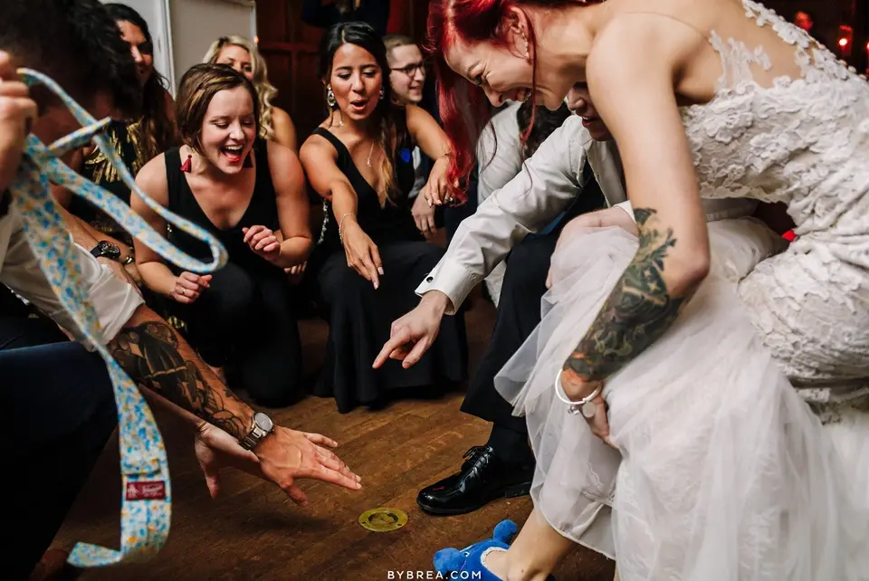 Guests crowding around the bride as she plays a game on the dance floor