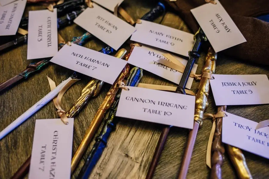 Name place cards with table numbers tied to wands laid out on a table