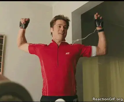 Man in a red cycling jersey and gloves raising his arms, in a reaction GIF still