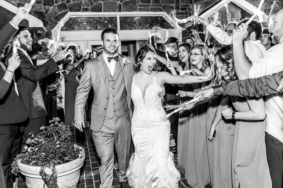 Bride and groom walking through guests holding sparklers during a wedding exit