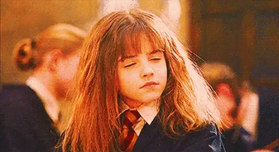 Animated GIF of a young girl with long hair and school robes closing her eyes with a smug look