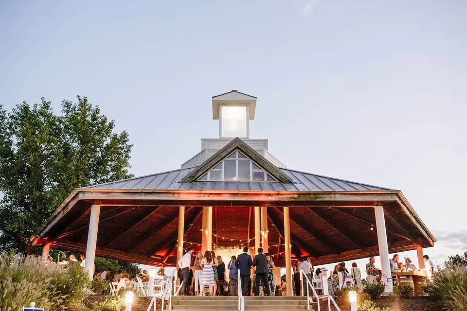 Guests gathered under a lit pavilion at an outdoor evening event