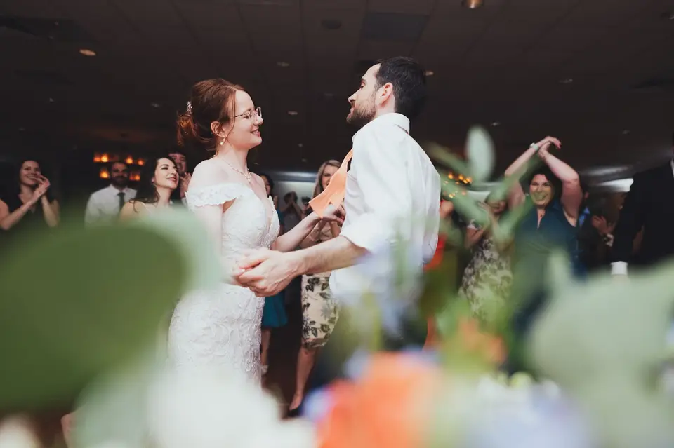 Natasha and Ben dancing and laughing together as guests clap behind them