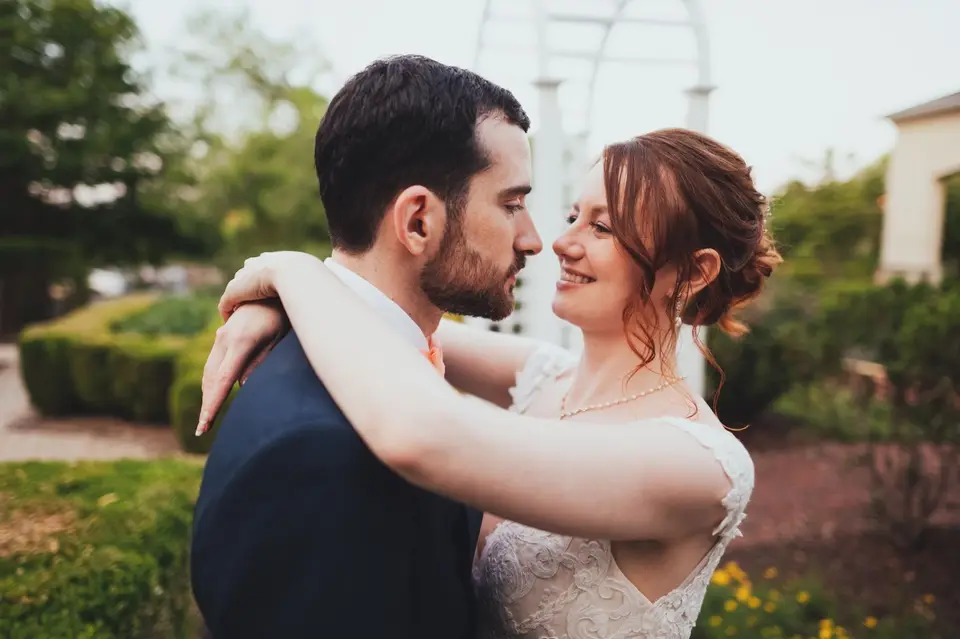 Natasha and Ben embracing outdoors in a garden, smiling at each other