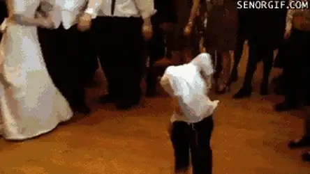 GIF of a small child in white dancing alone on a dance floor as adults in formal wear stand behind