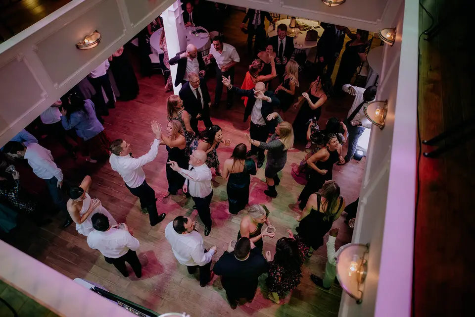 Overhead view of guests dancing on a wooden dance floor at a Herrington on the Bay reception