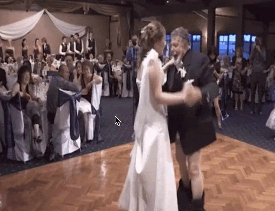 Animated GIF of a bride dancing with a man in a kilt on a parquet dance floor as guests watch