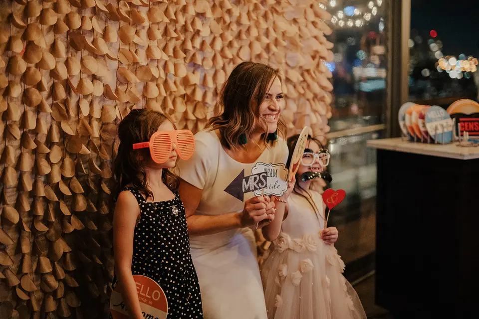 Image of a mother and her children holding props in front of a backdrop